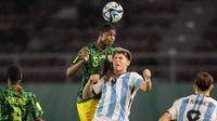 Pemain Timnas Mali U-17, Issa Traore (atas) memenangi duel udara dengan pemain Timnas Argentina U-17, Agustin Ruberto pada laga perebutan tempat ketiga Piala Dunia U-17 2023 di Stadion Manahan, Solo, Jumat (1/12/2023). (Bola.com/Bagaskara Lazuardi)