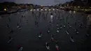 Para peserta ambil bagian dalam perlombaan dayung sambil berdiri pada Nautic SUP Paris di sepanjang sungai Seine, Paris, Minggu (3/12). Sekitar 700 peserta berpartisipasi menyeberangi sungai Seine dengan pemandangan kota Paris (AFP PHOTO/CHRISTOPHE SIMON)