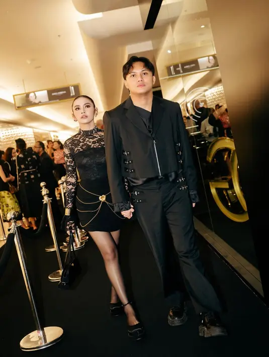 Mahalini Raharja tampil menawan dengan atasan long sleeve berkerah tinggi lace dan rok mini kerut. Aksen belt rantai tumpuk di bagian rok bikin busana polosnya terlihat glamor [@mahaliniraharja]