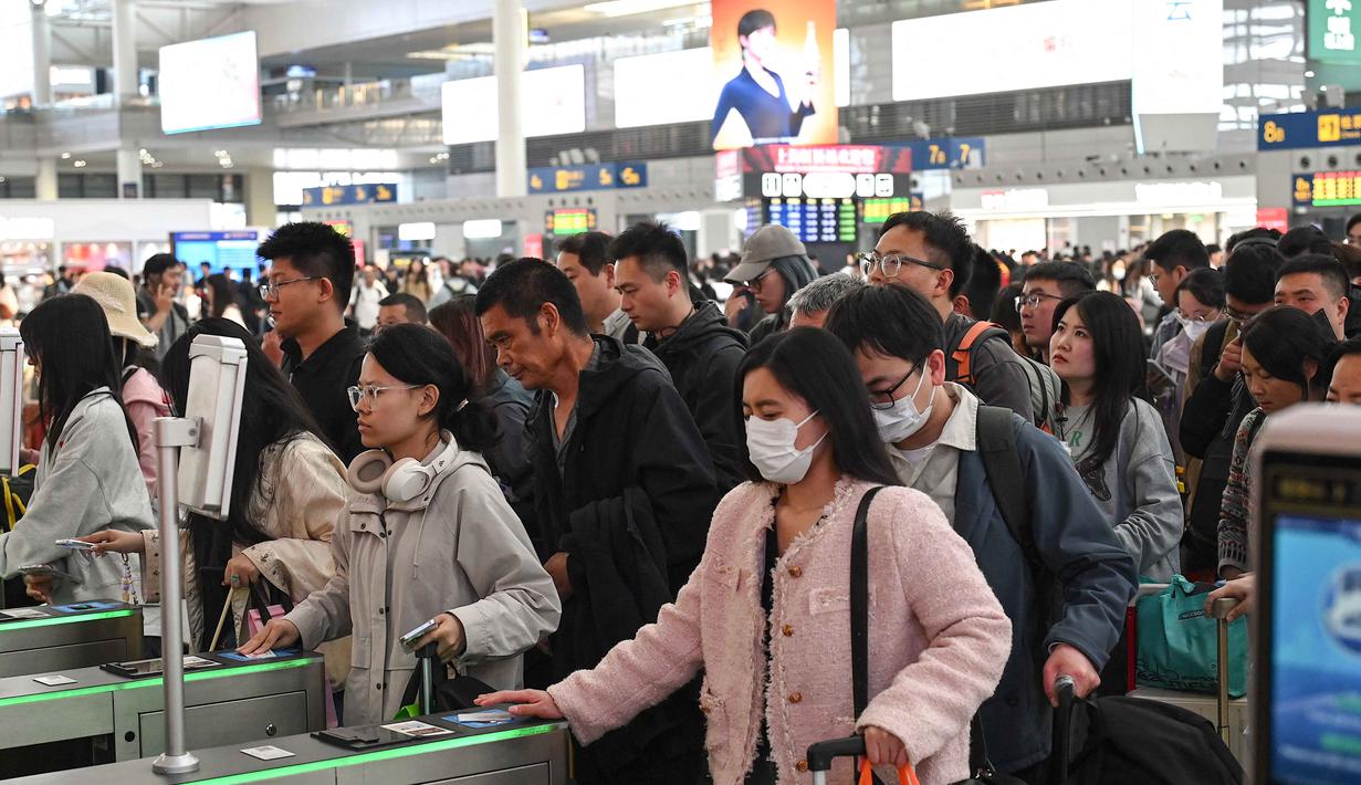 Tiongkok menjadi salah satu negara yang juga ikut merayakan Hari Buruh Internasional. Tampak dalam foto, para penumpang bersiap menaiki kereta di Stasiun Kereta Api Shanghai Hongqiao, Shanghai, Tiongkok, Kamis 30 April 2026, menjelang libur Hari Buruh yang dimulai pada 1 Mei. (JADE GAO/AFP)