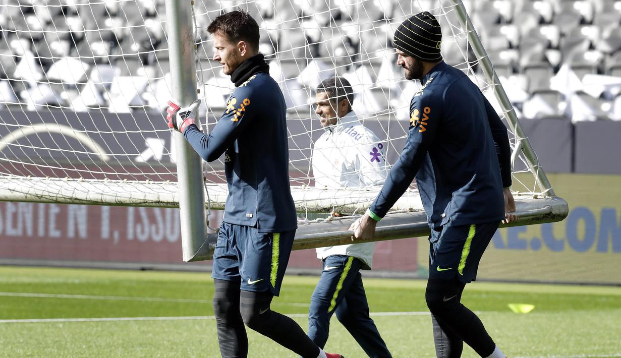 Kiper Brasil, Neto dan Alisson, menggotong gawang saat latihan jelang laga persahabatan di Berlin, Jerman, Selasa, (27/3/2018). Brasil akan berhadapan dengan Jerman. (AP/Michael Sohn)