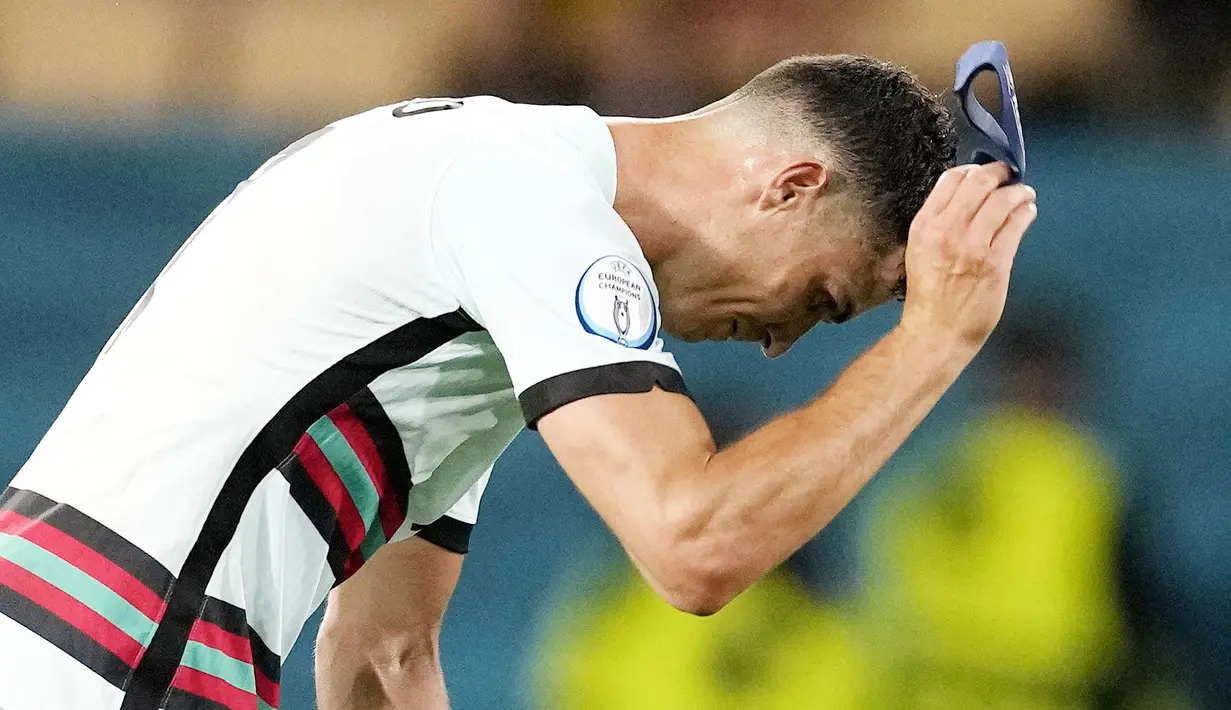 Bintang Timnas Portugal, Cristiano Ronaldo, tak mampu menutupi kekecewaan usai timnya didepak Belgia pada babak 16 besar Euro 2020. (AP/Thanassis Stavrakis, Pool)