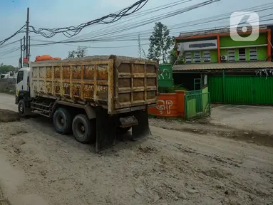 Petugas melakukan penambalan jalan berlubang di Jalan Muhammad Toha, Parung Panjang, Bogor, Jawa Barat, Rabu (22/11/2023). (merdeka.com/Arie Basuki)