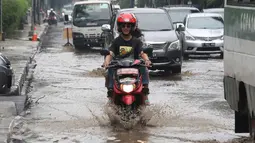 Pengendara motor mencoba menerobos genangan air di Jalan Cikini Raya, Jakarta, Sabtu (7/11). Meski baru pertama kali diguyur hujan selama musim kemarau, jalan tersebut langsung terendam air. (Liputan6.com/ Immanuel Antonius)