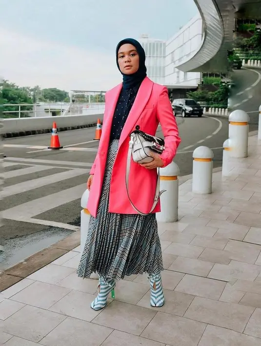 Gaya canggih ala model Tantri Namirah berikut ini yang memadukan polkadot shirt, pleats skirt, dan blazer pink ini bisa bikin tampilan mu terlihat lebih stunning. (Instagram/tantrinamirah).