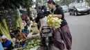 Seorang wanita usai membeli kulit ketupat di Pasar Palmerah, Jakarta, Senin (2/6/2019). Peningkatan drastis dikarenakan banyak warga yang ingin membuat masakan khas Lebaran seperti Opor Ayam yang selalu ditemani ketupat sebagai pengganti lontong. (Liputan6.com/Faizal Fanai)