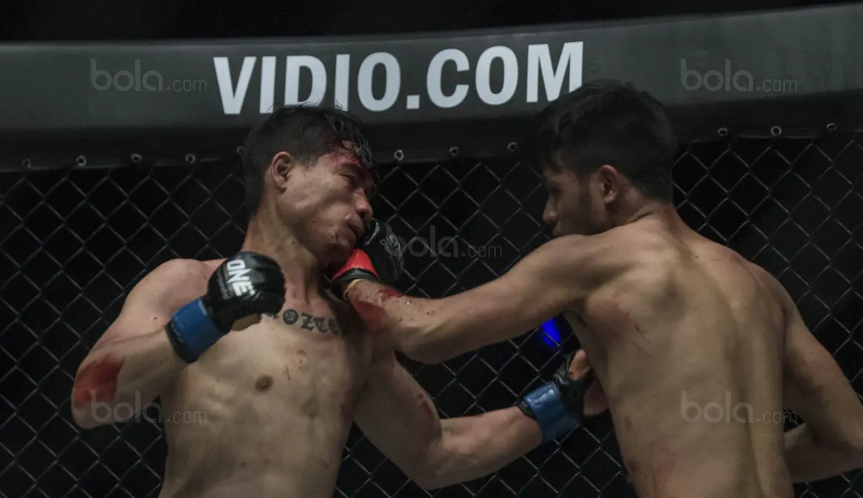 Petarung Indonesia, Rizki Umur, memukul lawannya Egi Rozten (kiri) saat laga One Championship di JCC Senayan, Jakarta, Sabtu (20/1/2018). Rizki berhasil mengalahkan Egi. (Bola.com/Vitalis Yogi Trisna)