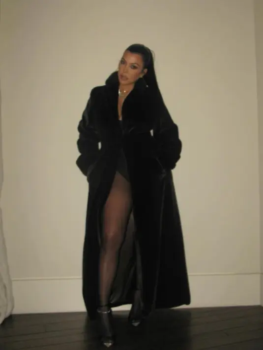 Kourtney yang berusia 44 tahun yang baru saja melahirkan putranya Rocky dengan suaminya Travis Barker bulan lalu memilih mantel hitam berbulu halus yang ditata dengan celana ketat tipis dan bodysuit. [@kourtneykardash]