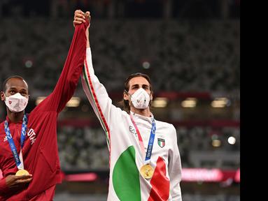 Atlet Qatar, Mutaz Barshim dan atlet asal Italia, Gianmarco Tamberi harus berbagi medali emas nomor lompat tinggi putra Olimpiade Tokyo 2020 di Olympic Stadium, Minggu (1/8/2021). (Foto: AFP/Ina Fassbender)