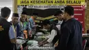 Panitia Penyelenggara Ibadah Haji (PPIH) memberikan perlengkapan untuk calon jemaah haji kloter pertama di Asrama Haji, Jakarta, Sabtu (6/7/2019). Sebelum diberangkatkan, petugas mengecek kembali 385 calon jamaah untuk melakukan kelengkapan administrasi. (Liputan6.com/Faizal Fanani)