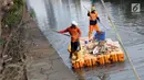 Petugas UPK Badan Air Pemprov DKI Jakarta membersihkan ceceran sampah di sepanjang Anak Sungai Ciliwung yang membelah kawasan Jalan Gajah Mada dan Hayam Wuruk, Selasa (9/7/2019). Pembersihan ini untuk menghindari penumpukan sampah dan memperlancar aliran air. (Liputan6.com/Helmi Fithriansyah)