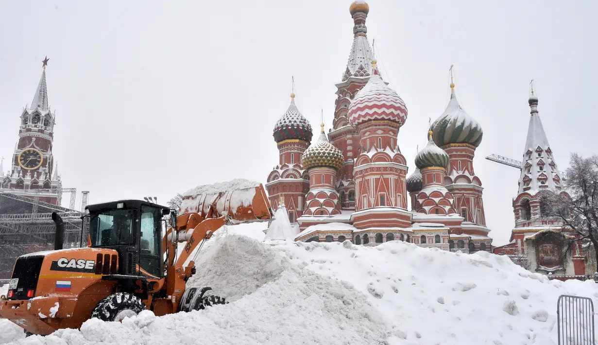 Sebuah buldozer digunakan untuk mengeruk salju di lapangan Red Square, Moskow (4/2). Hujan salju lebat yang turun semalaman mengakibatkan jalan-jalan dan bangunan di pusat kota dan beberapa daerah di Rusia tertutup salju. (AFP/Vasily Maximov)