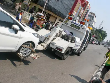 Sebuah mobil berwarna putih diangkut petugas Dishub di kawasan Fatmawati, Jakarta, Selasa (23/9/2014) (Liputan6.com/Faizal Fanani)