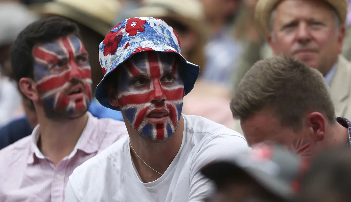 Beberapa suporter dengan wajah bergambar bendera Inggris hadir mendukung Andy Murray  saat melawan Sam Querrey pada perempat final Wimbledon 2017 di The All England Lawn Tennis Club, London, (12/7/2017). (AFP/Daniel Leal-Olivas)