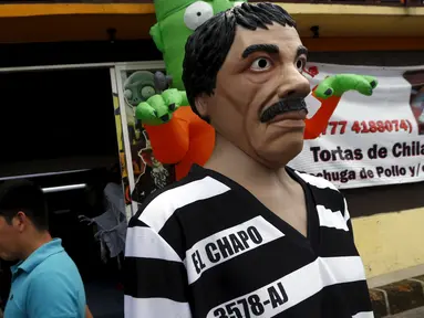 Sebuah patung dikenakan topeng gembong narboka "El Chapo" Guzman di pinggir jalanan kota Meksiko, Kamis (15/10/2015). Topeng gembong narkoba "El Chapo" diperjualkan menjelang Halloween. (REUTERS/Henry Romero)