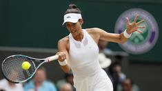 Garbine Muguruza berusaha mengembalikan bola ke arah lawannya Magdalena Rybarikova pada laga semifinal tunggal putri Wimbledon 2017 di London, (13/7/2017). (AP/Kirsty Wigglesworth)