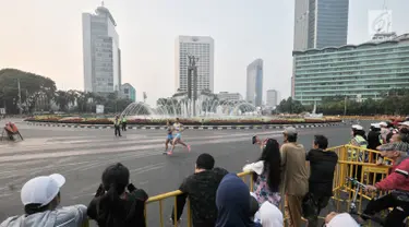 Warga menyaksikan lomba lari maraton putri Asian Games 2018 di kawasan MH Thamrin, Jakarta, Minggu (26/8). Meski Car Free Day ditiadakan, warga Ibu Kota tetap memadati kawasan MH Thamrin menyaksikan maraton Asian Games 2018. (Merdeka.com/Iqbal S. Nugroho)