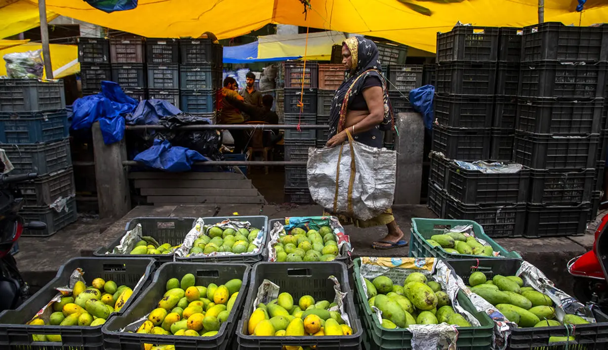 Seorang wanita berjalan di pasar di Gauhati, India, Rabu (9/6/2021). India melonggarkan sebagian pembatasan untuk mengekang penyebaran virus corona COVID-19. (AP Photo/Anupam Nath)