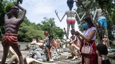 Para pengunjung mengambil foto di depan patung-patung yang menggambarkan nasib orang-orang yang tidak menjunjung tinggi lima ajaran Buddha di sebuah taman yang menggambarkan neraka versi Buddha di kuil Wat Saeng Suk di provinsi pantai Thailand Chonburi (9/7/2020). (AFP/Lillian Suwanrumpha)