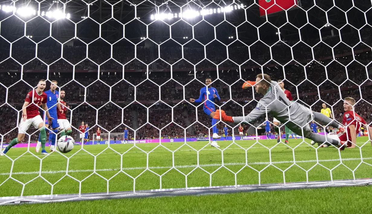 Pemain Inggris Raheem Sterling (kedua kanan) mencetak gol ke gawang kiper Hungaria Peter Gulacsi (kanan) pada pertandingan sepak bola Grup I kualifikasi Piala Dunia 2022 di Puskas Ferenc Arena, Budapest, Hungaria, Kamis (2/9/2021). Inggris menang 4-0. (Zsolt Szigetvary/MTI via AP)