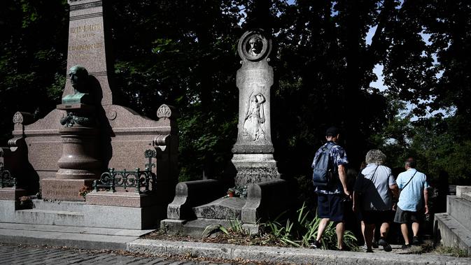 Turis mengunjungi pemakaman Pere Lachaise di Paris (22/7/2019). Pemakaman ini dikenal di seluruh dunia sebagai tempat peristirahatan orang-orang terkenal dari berbagai kalangan, mulai dari seniman, bintang film, musisi, politisi, pelukis, penulis, sampai ilmuwan. (AFP Photo/Philippe Lopez)