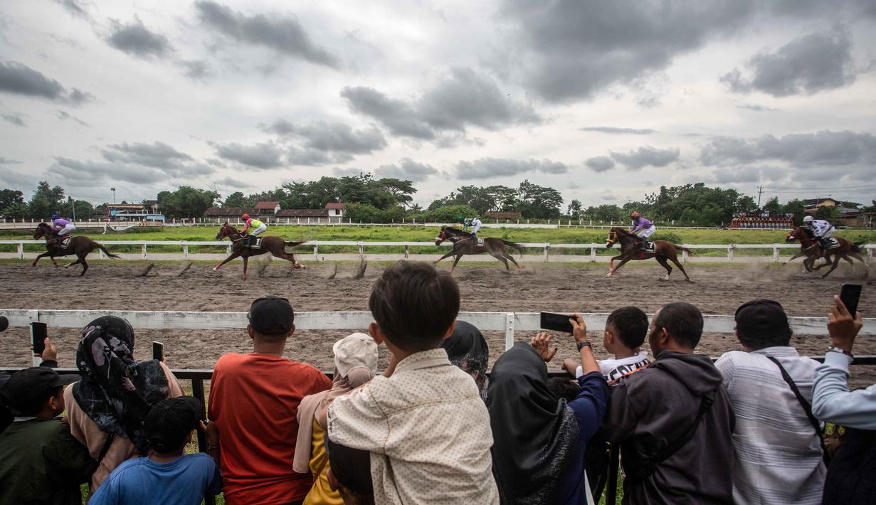 Orang-orang menonton balapan kuda dalam ajang Piala Raja Hamengku Buwono X 2025, kejuaraan balap kuda nasional tahunan yang memperebutkan trofi Sultan Hamengku Buwono X, di lintasan Sultan Agung, Bantul, Yogyakarta, pada Minggu 9 November 2025. Indonesia's Horse Racing (IHR) Piala Raja Hamengku Buwono (HB) X 2025 sukses digelar di Lapangan Pacuan Kuda Sultan Agung, DI Yogyakarta, Minggu (9/11/2025). (DEVI RAHMAN/AFP)