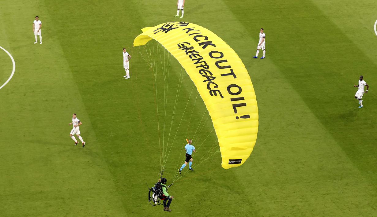 Di parasut kuning ciri khas Greenpeace saat melakukan aksi tertulis "Kick Out Oil! Greenpeace". (Foto: AP/Pool/Alexander Hassenstein)