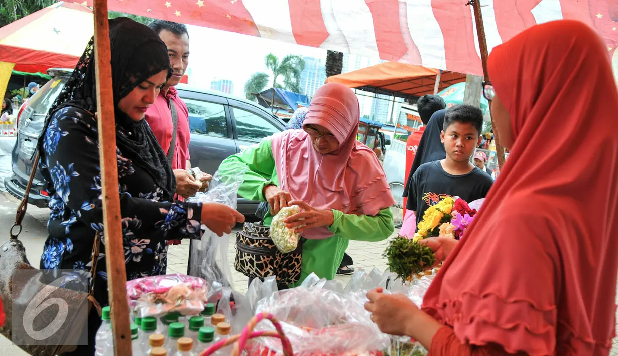 Penjual kembang melayani pembeli yang hendak ziarah di TPU Karet Bivak, Jakarta, Minggu (29/5/2016). Banyaknya warga yang ziarah menjelang Ramadan menjadi berkah tersendiri bagi penjual kembang. (Liputan6.com/Yoppy Renato)