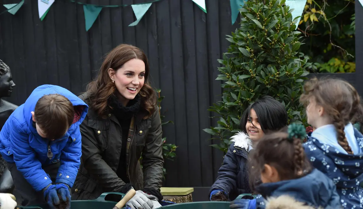 Kate Middleton berbincang dengan anak-anak saat mengunjungi Sekolah Dasar Robin Hood di London, Inggris (29/11). Kedatangan Kate Middleton untuk merayakan sepuluh tahun Kampanye The Royal Horticultural Society (RHS). (AFP Photo/Pool/Eddie Mulholland)