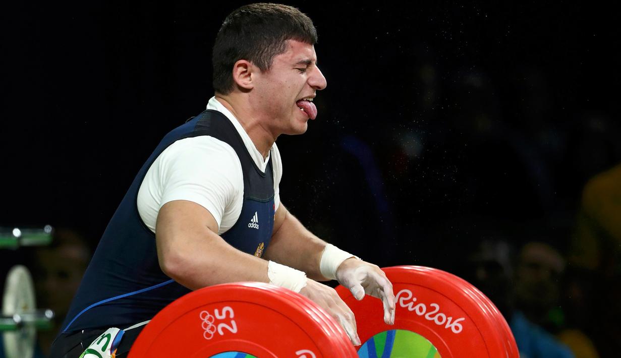 Ekspresi atlet angkat besi Armenia, Andranik Karapetyan ketika berusaha mengangkat beban di nomor 77 kg putra pada Olimpiade 2016 di Rio de Janeiro, Rabu (10/8). Siku Karapetyan patah saat hendak mengangkat beban 195 kilogram. (REUTERS/Stoyan Nenov)