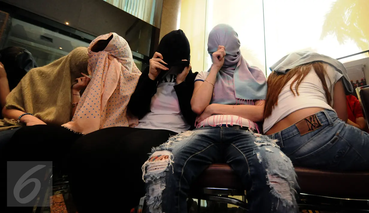 Beberapa perempuan warga negara asing illegal yang terjaring operasi pengawasan menutupi wajah saat rilis di Ditjen Imigrasi, Jakarta, Jumat (13/1). Diduga, para WNA tersebut bekerja sebagai pekerja seks komersial (PSK). (Liputan6.com/Helmi Fithriansyah)