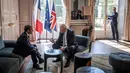 Presiden Prancis Emmanuel Macron berbincang dengan PM Inggris, Boris Johnson dalam kunjungan kenegaraan di Istana Elysee, Paris, Kamis (22/8/2019). Dalam pertemuan, Johnson tertangkap kamera bercanda ke arah kamera dan meletakkan kakinya di meja kopi. (Christophe Petit Tesson, Pool via AP)