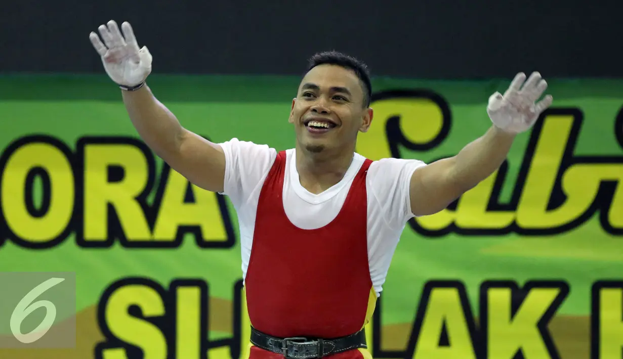 Lifter Jawa Timur, Eko Yuli Irawan mengangkat tangan usai memastikan emas di kelas 62kg putra PON XIX Jabar di Gymnasium Stadion Si Jalak Harupat, Kab Bandung, Selasa (20/9/2016). Total angkatan Eko Yuli mencapai 307kg. (Liputan6.com/Helmi Fithriansyah)