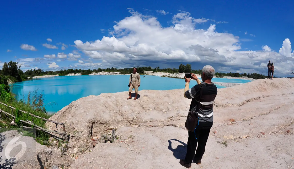Wisatawan berpose di tepi Danau Kaolin, Belitung, Selasa (8/3/2016). Danau ini terbentuk dari bekas tempat pertambangan Kaolin yang telah ditinggalkan. (Foto: Gholib)
