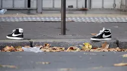 Sepasang sepatu yang tertinggal dipinggir jalan dimana tempat penembakan terjadi di Paris, Prancis, Sabtu (14/11/2015). Dikabarkan ratusan orang tewas dalam serangan ini. (REUTERS/Charles Platiau)