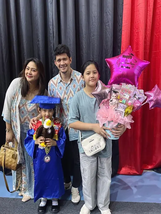 Anak Iko Uwais dan Audy Item baru saja wisuda TK. Mereka pun hadir mengenakan batik nuansa biru muda-cokelat. [@audyitem]