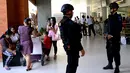 Dua anggota polisi melakukan pengamanan di Bandara Ngurah Rai, Denpasar, Bali, Jumat (15/1). Pasca peristiwa serangan di Sarinah, Jakarta, pengelola Bandara Internasional I Gusti Ngurah Rai, Bali perketat pengamanan. (AFP PHOTO/Sonny Tumbelaka)
