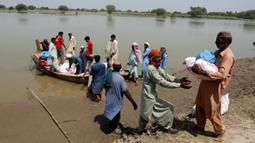 Korban banjir saat menerima bantuan Yayasan Edhi di Distrik Ghotki, Sindh Pakistan, Rabu (7/9/2022). Akses ke air bersih adalah masalah terbesar bagi mereka yang mencoba mencari makanan dan tempat tinggal. (AP Photo/Fareed Khan)