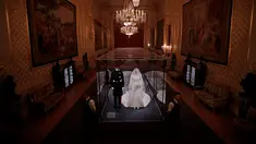 Petugas berjaga dekat gaun pernikahan Meghan Markle dan Pangeran Harry yang ditampilkan pada pameran “A Royal Wedding: The Duke and Duchess of Sussex” di Kastil Windsor, London, 25 Oktober 2018. Pameran ini dibuka hingga Januari 2019. (AP/Matt Dunham)