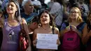 Seorang wanita memegang tulisan bernada protes saat unjuk rasa di Ibu Kota Argentina, Buenos Aires, Selasa (7/1). Aksi itu sebagai bentuk protes atas kekerasan yang dilakukan aparat kepolisian terhadap perempuan tanpa bra. (AP Photo/Natacha Pisarenko)