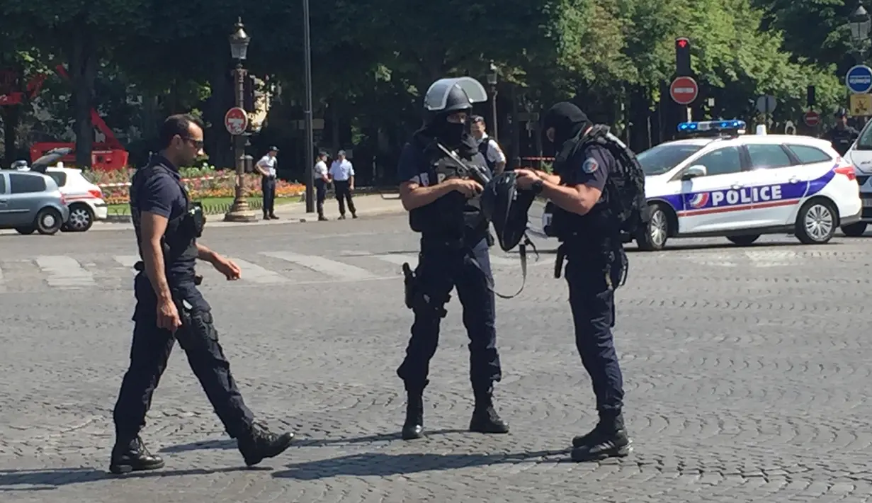 Petugas kepolisian menutup akses jalan Champs Elysees di Paris, Prancis, Senin (19/6). Seorang laki-laki yang diduga terkait dengan ekstrimis menabrakkan mobilnya ke arah mobil van polisi di jalanan ikonik itu. (AP Photo/Bertrand Combaldieu)