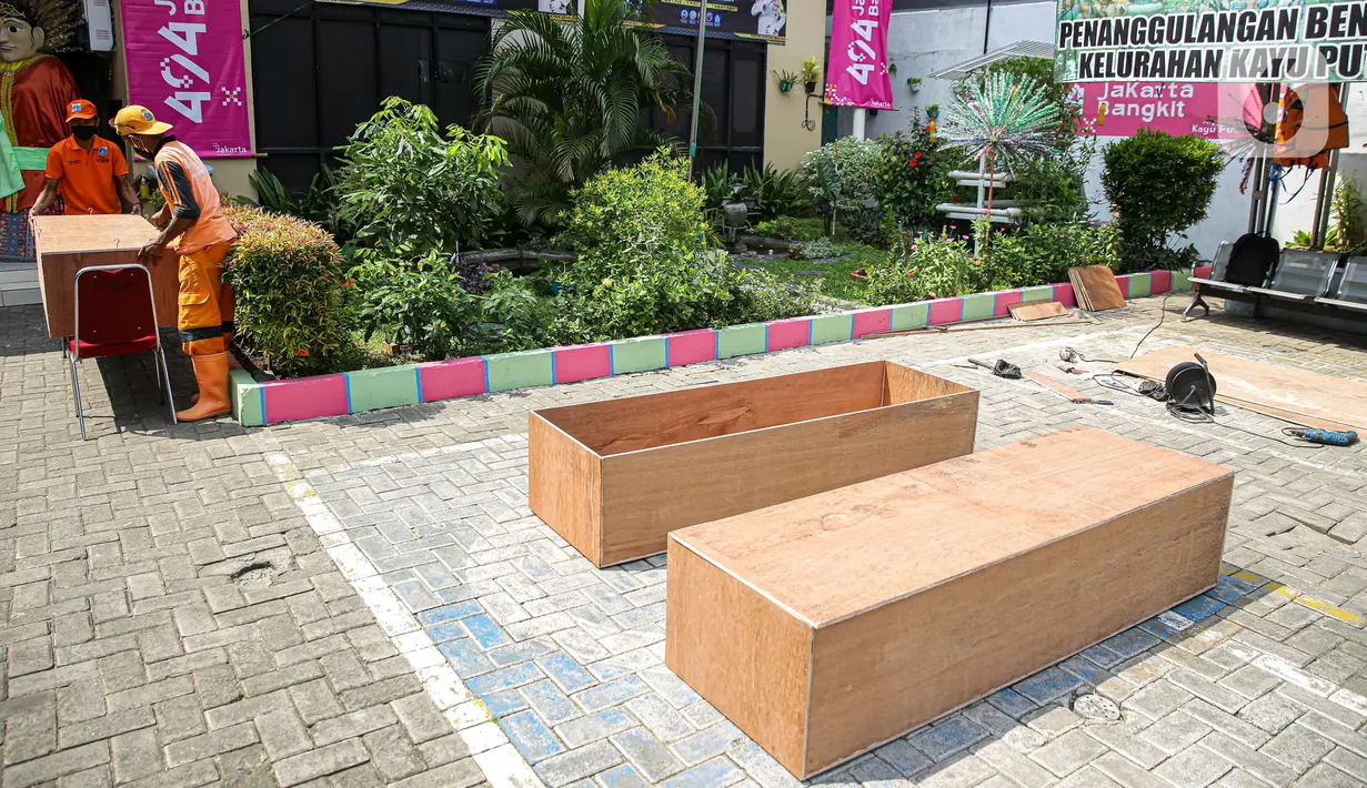 Peti jenazah yang dibuat petugas PPSU di Kantor Kelurahan Kayu Putih, Jakarta, Selasa, (6/7/2021). Kelurahan Kayu Putih berinisiatif membuat peti jenazah dilatar belakangi warganya yang terkendala ketersediaan peti saat angka kematian COVID-19 meningkat di DKI. (Liputan6.com/Faizal Fanani)