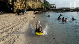 Wisatawan menikmati kolam renang alami yang terbentuk saat air laut surut di kawasan Pantai Suluban, Uluwatu, Bali, Selasa (7/9/2021). Keunikan Pantai Suluban dengan kolam-kolam yang terbentuk di atas karang menjadi daya tarik wisatawan. (merdeka.com/Arie Basuki)