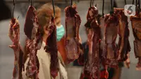 Deretan daging sapi tergantung di lapak pedagang di Pasar Perumnas, Jakarta, Selasa (19/1/2021). Biasanya, harga daging sapi berada di kisaran Rp 110 ribu sampai Rp 114 ribu per kilogram. (merdeka.com/Imam Buhori)