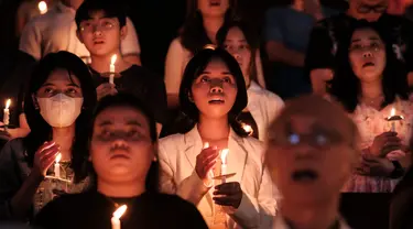 Umat Katolik memegang lilin saat Malam Paskah di gereja Santo Kristoforos di Jakarta pada 30 Maret 2024. (Yasuyoshi CHIBA/AFP)