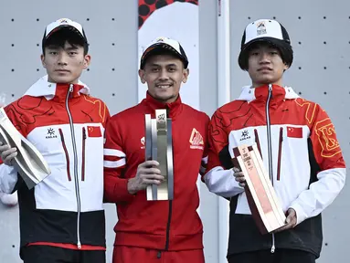 Atlet panjat tebing Indonesia, Veddriq Leonardo (tengah) menjadi juara dalam ajang Kualifikasi Olimpiade 2024 panjat tebing nomor speed di Shanghai, China, Sabtu (18/05/2024) waktu setempat. (AFP/Wang Zhao)