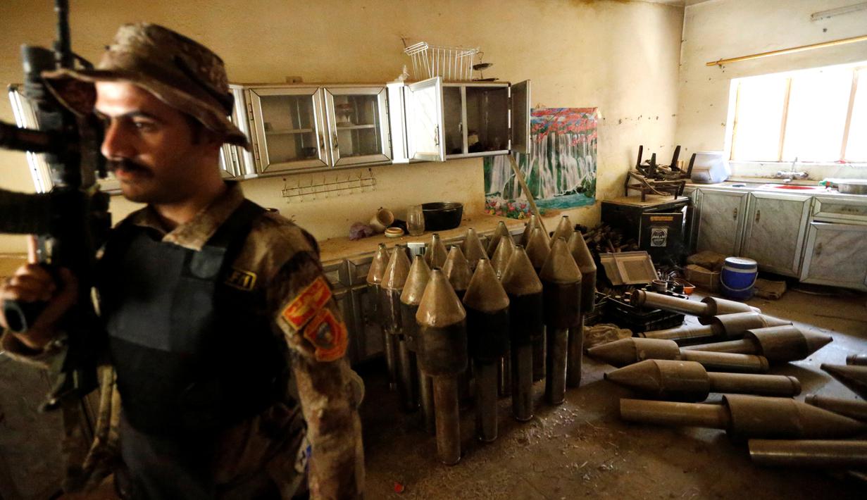 Seorang anggota pasukan kontraterorisme Irak berjaga di bangunan yang digunakan sebagai pabrik senjata militan ISIS yang berhasil ditemukan di Fallujah, Irak, Kamis (23/6). (REUTERS/Thaier Al-Sudani)