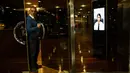 Seorang porter keluar dari pintu sebuah gedung di Buenos Aires, Argentina, Jumat (13/4). Argentina mulai menerapkan penjaga keamanan virtual di sujumlah gedung. (AP Photo/Rodrigo Abd)