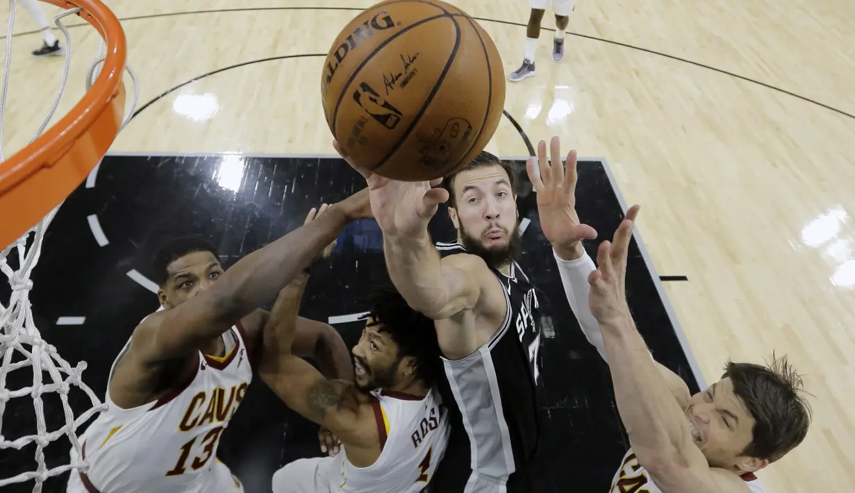 Aksi pemain San Antonio Spurs, Joffrey Lauvergne (2kanan) berusaha mencetak poin saat diadang tiga pemain Cleveland Cavaliers pada lanjutan NBA di basketball game di AT&T Center, San Antonio, (23/1/2018). Spurs menang atas Cleveland 114—102. (AP/Eric Gay)