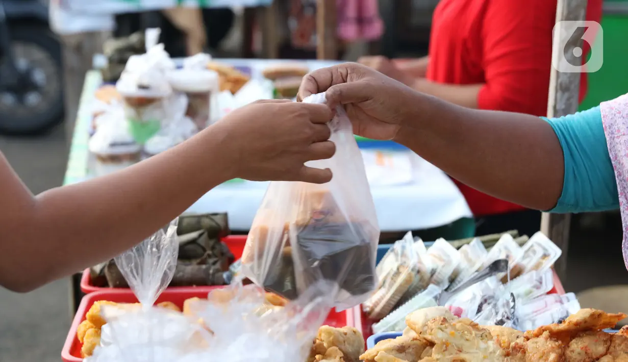 Warga melakukan aktivitas jual beli makanan untuk berbuka puasa (takjil) di kawasan Jalan Panjang, Jakarta, Selasa (5/5/2020). Pandemi virus COVID-19 dan pelaksanaan Pembatasan Sosial Berskala Besar (PSBB) berimbas pada sepinya pembeli takjil di kawasan tersebut. (Liputan6.com/Helmi Fithriansyah)